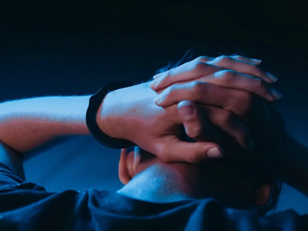 close up shot of an arrested person with handcuffs